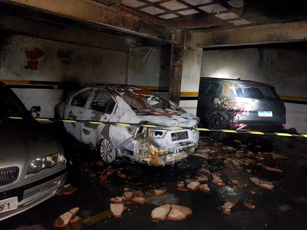 Bombeiros combatem incêndio em carro na garagem de prédio no Centro de Moc